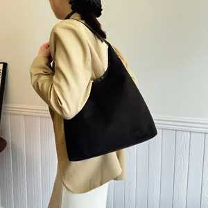 Minimalist large black suede hobo tote bag for women worn by model with khaki blazer