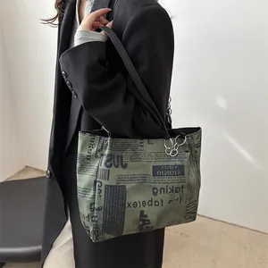Borsa tote verde militare con stampa di giornale e dettaglio catena in interno di classe