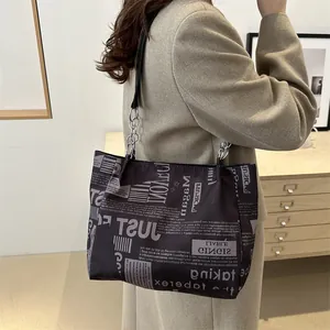 Borsa tote vintage con stampa a giornale e spallacci in catena metallica argentata