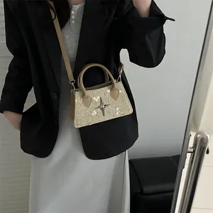 Beige straw tote bag with floral embroidery and brown leather handles on model