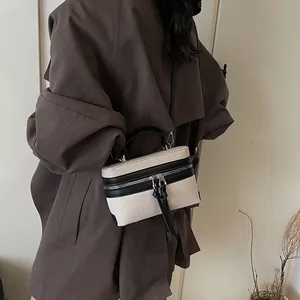 Sac boîte en toile contrastée avec bordures en cuir noir et détail de gland élégant