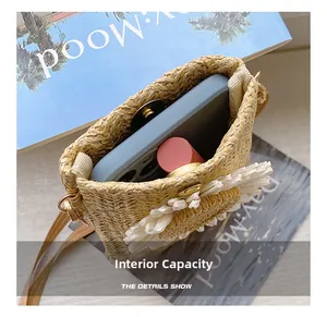 Internal capacity of straw woven bag with daisy detail showing phone and lipstick