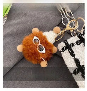 Close-up of a brown plush charm with a white knit hat and sunglasses on a tote bag