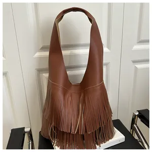 Macro detail of brown lychee leather shoulder bag featuring dense double-layer fringes