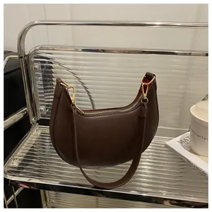 Detail of dark brown hobo bag showing pebbled leather texture and gold zipper hardware
