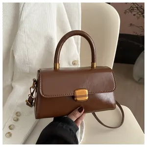 Detail of caramel brown retro handbag with glossy oil-wax leather and gold hardware