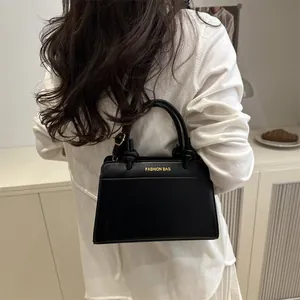 Minimalist black leather saddle bag with gold lettering shown in a lifestyle setting