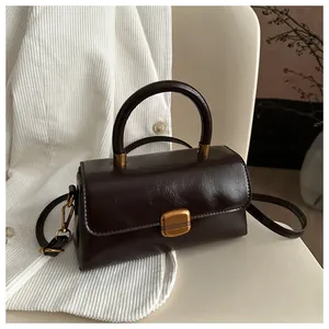 Detailed macro view of chocolate oil wax leather handbag with vintage golden clasp