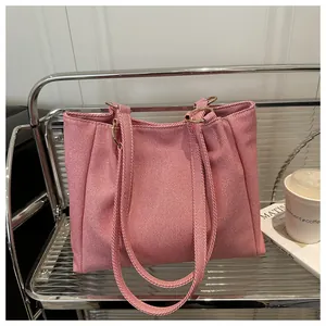 Detail view of the woven pink tote bag with metal ring connectors and long shoulder strap