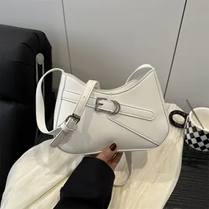Elegante bolso de hombro blanco minimalista con hebilla plateada en un ambiente moderno
