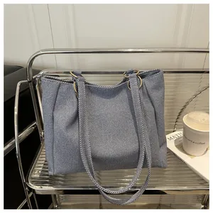 Detail of blue and white twill canvas tote bag with gold metal rings and double handles