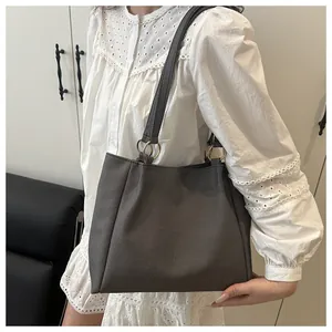 Detail of grey canvas tote bag featuring premium gold metal ring strap connectors