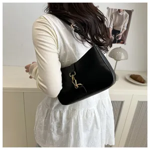Detail view of a black smooth leather crescent shoulder bag with golden metallic buckle closure