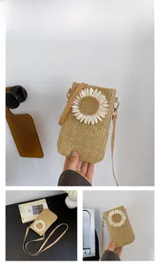 Close-up of straw woven crossbody bag with white crochet daisy detail in khaki finish