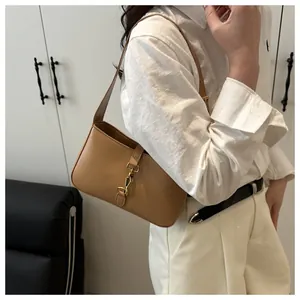 Detail of warm camel shoulder bag with metallic clasp and smooth leather texture