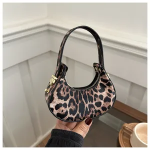 Détails du sac croissant à imprimé léopard avec ferrures dorées et anse noire