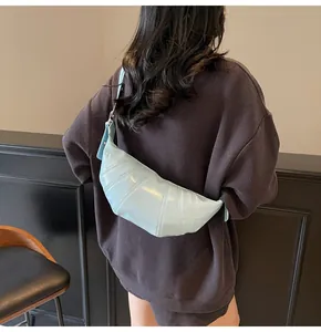 Rear view of a model wearing a light blue croissant bag with segmented stitching