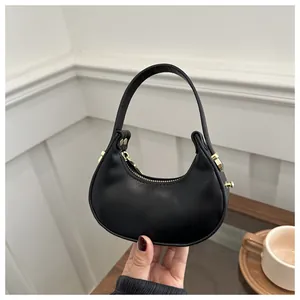 Détail du sac croissant noir en similicuir mat avec boucle métallique dorée chic