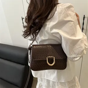 Retro dark brown croc-embossed shoulder bag with golden horseshoe buckle worn with a white shirt