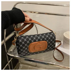 Close-up of printed shoulder bag with brown leather G logo and chain pattern detail
