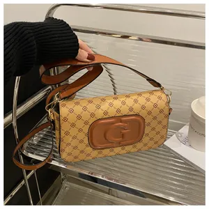Close-up of vintage brown patterned handbag with gold G buckle and leather strap