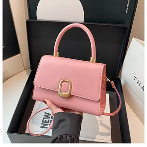 Pink minimalist handbag featuring a gold oval buckle and stylish crossbody strap detail