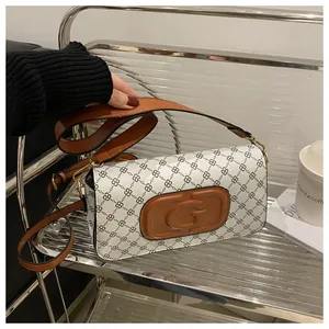 Close-up of vintage printed crossbody bag with embossed leather G logo and chain pattern
