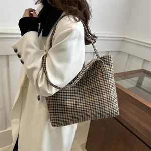 Classic houndstooth large capacity tote bag worn by a model in a professional office setting