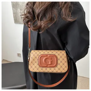 Detail view of the vintage floral print on the rectangular shoulder bag and its metal hardware