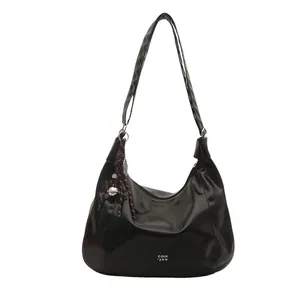 Chic black glossy PU leather tote bag with shoulder strap and stylish knot pendant