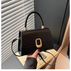 Detailed view of black leather handbag with elegant gold hardware and smooth handle