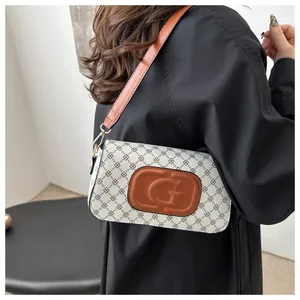Detail view of stylish white shoulder bag with black monogram print and brown leather G logo