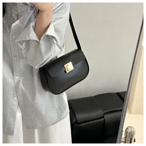 Détail du sac à bandoulière en cuir lisse noir avec boucle rectangulaire dorée