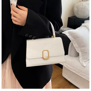 Detail of a white leather handbag with elegant gold metal buckle and sturdy top handle