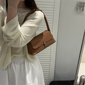 Elegant brown leather underarm handbag with vintage gold buckle for women in spring fashion