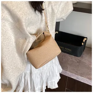Detailed view of the woven texture and golden metal buckle on this khaki crossbody bag