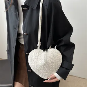 White heart-shaped crossbody bag with crocodile pattern and dual zippers for women