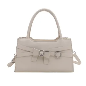 Minimalist beige crossbody handbag for women featuring a stylish front bow and top handle