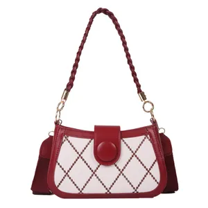 Quilted crossbody bag with red diamond stitching and a stylish braided top handle