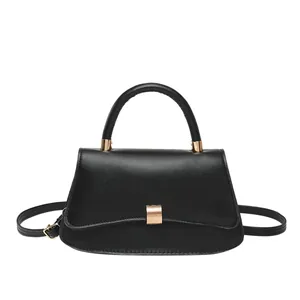 Minimalist black leather underarm bag with gold metal buckle and top handle for women
