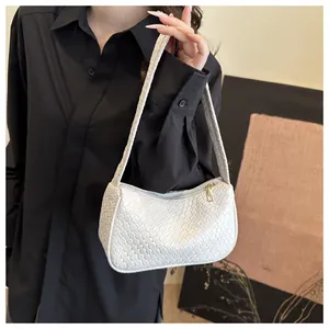 Detailed close-up of the white woven texture and metallic zipper on the shoulder bag