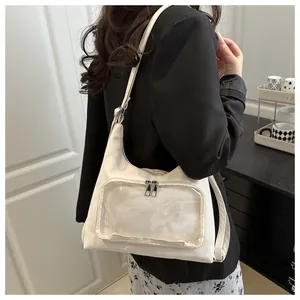 Detail view of cream-white ita bag featuring a large clear window and adjustable strap