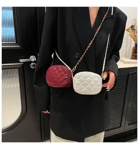 Détail de mini sacs matelassés bordeaux et blancs avec bandoulière en chaîne