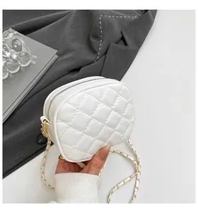 Détail du mini sac rond blanc matelassé avec bandoulière en chaîne dorée et zip