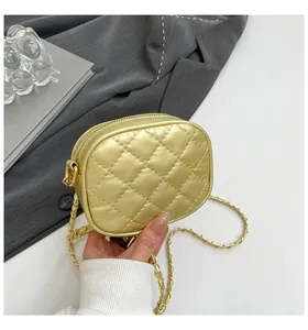 Gros plan sur le mini sac rond matelassé doré clair avec bandoulière chaîne en métal