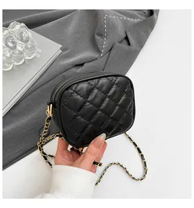 Détails du similicuir matelassé noir et de la chaîne dorée du mini sac rond chic