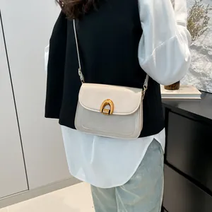 Chic cream leather saddle shoulder bag with vintage gold arch buckle for women