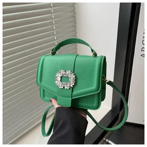 Macro shot of green pebble leather texture and luxury sparkling crystal buckle on handbag