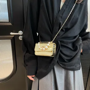 Mini gold crocodile texture crossbody bag with elegant pearl handle and metal chain strap