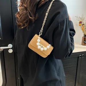 Brown crocodile pattern mini chain bag with elegant pearls shown in a lifestyle shot